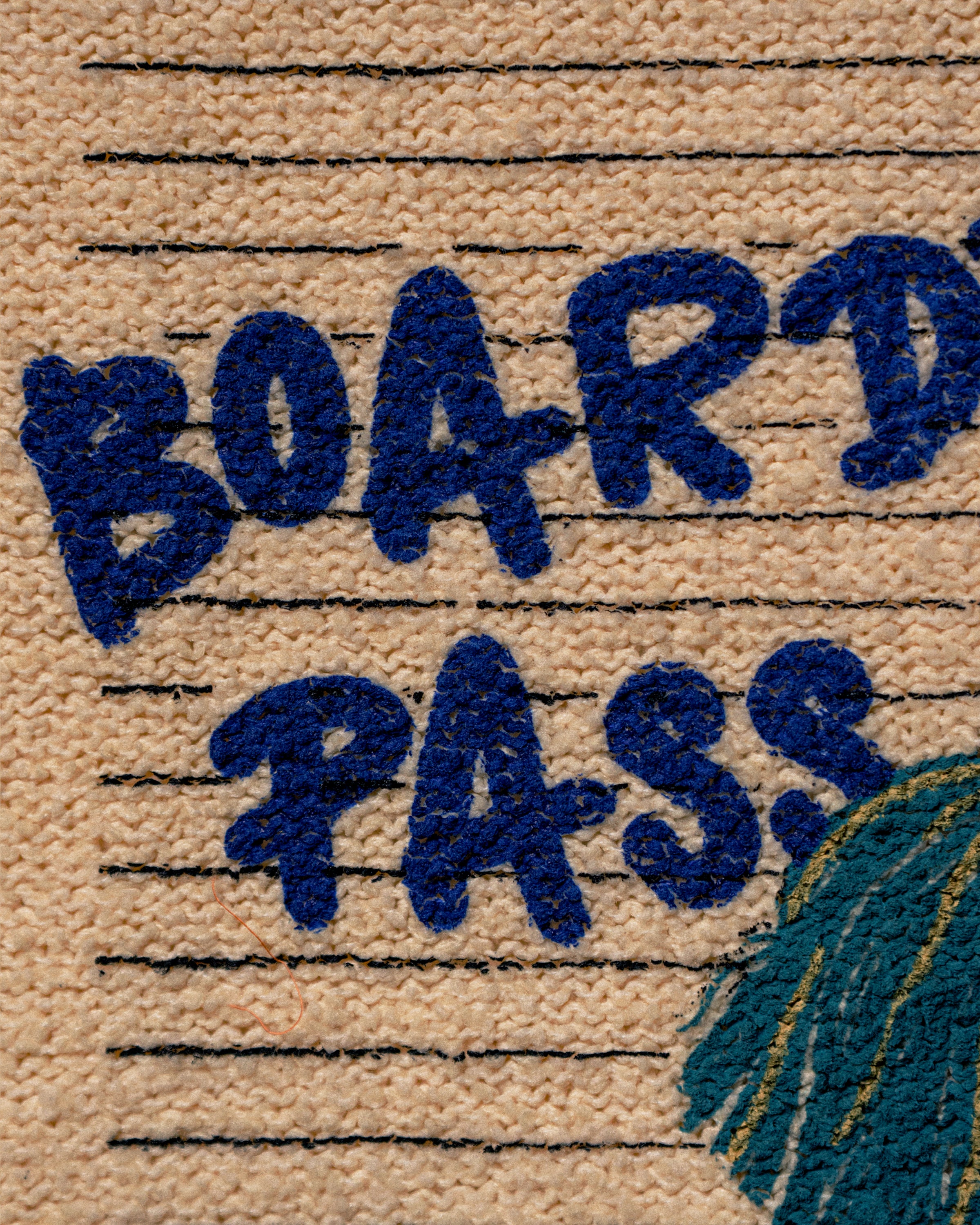 Close-up of a woven rug or carpet with the words "BOARD PASS" in dark blue raised lettering on a beige background with thin black horizontal lines. Part of a teal and gold graphic appears in the lower right corner.