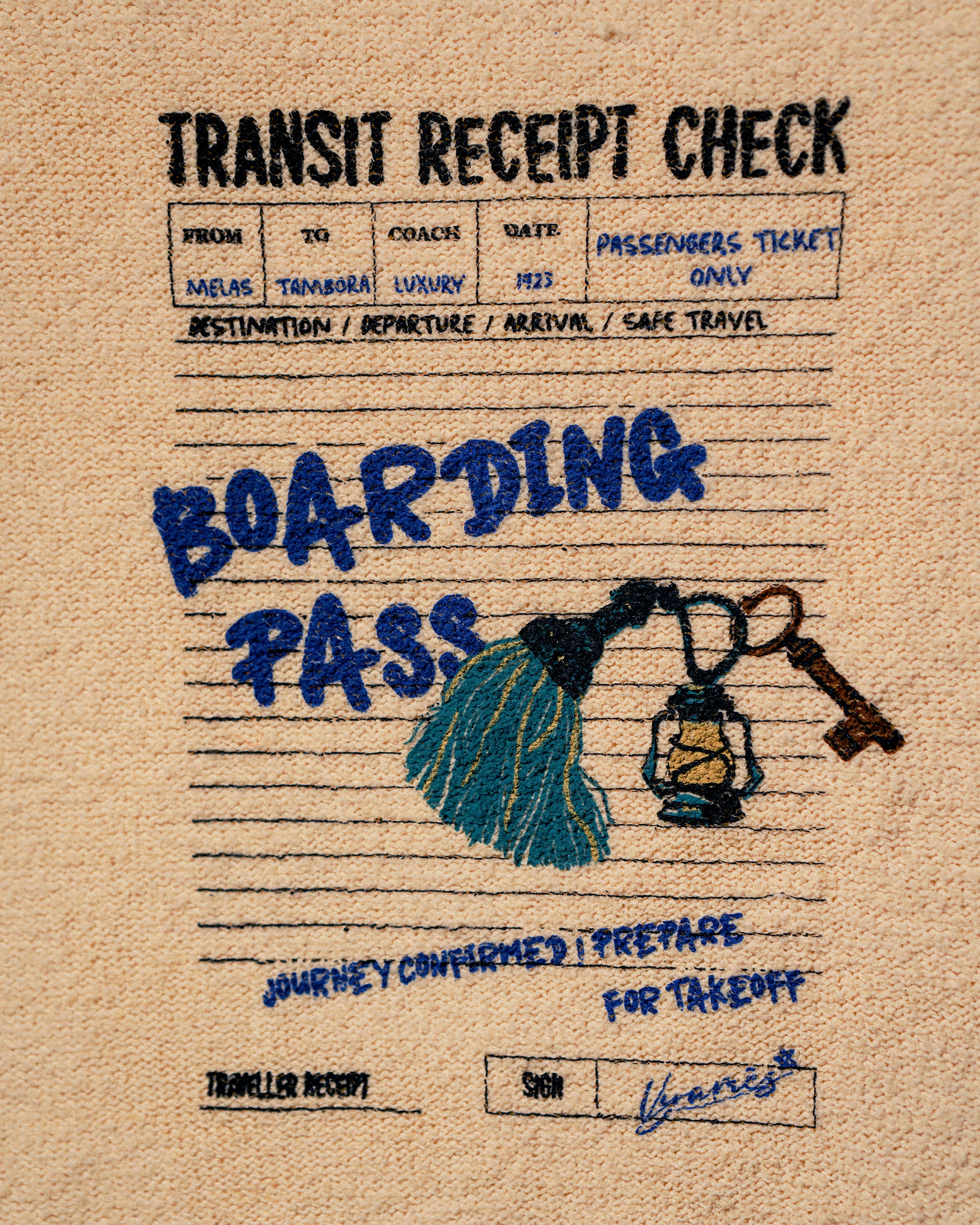 A close-up of a beige woven fabric item, likely a bag or pouch, featuring a printed and embroidered 'Transit Receipt Check' style design. The design includes blue embroidered text reading 'BOARDING PASS', a blue tassel, a blue lantern, and a brown key, with black and blue printed text at the top.