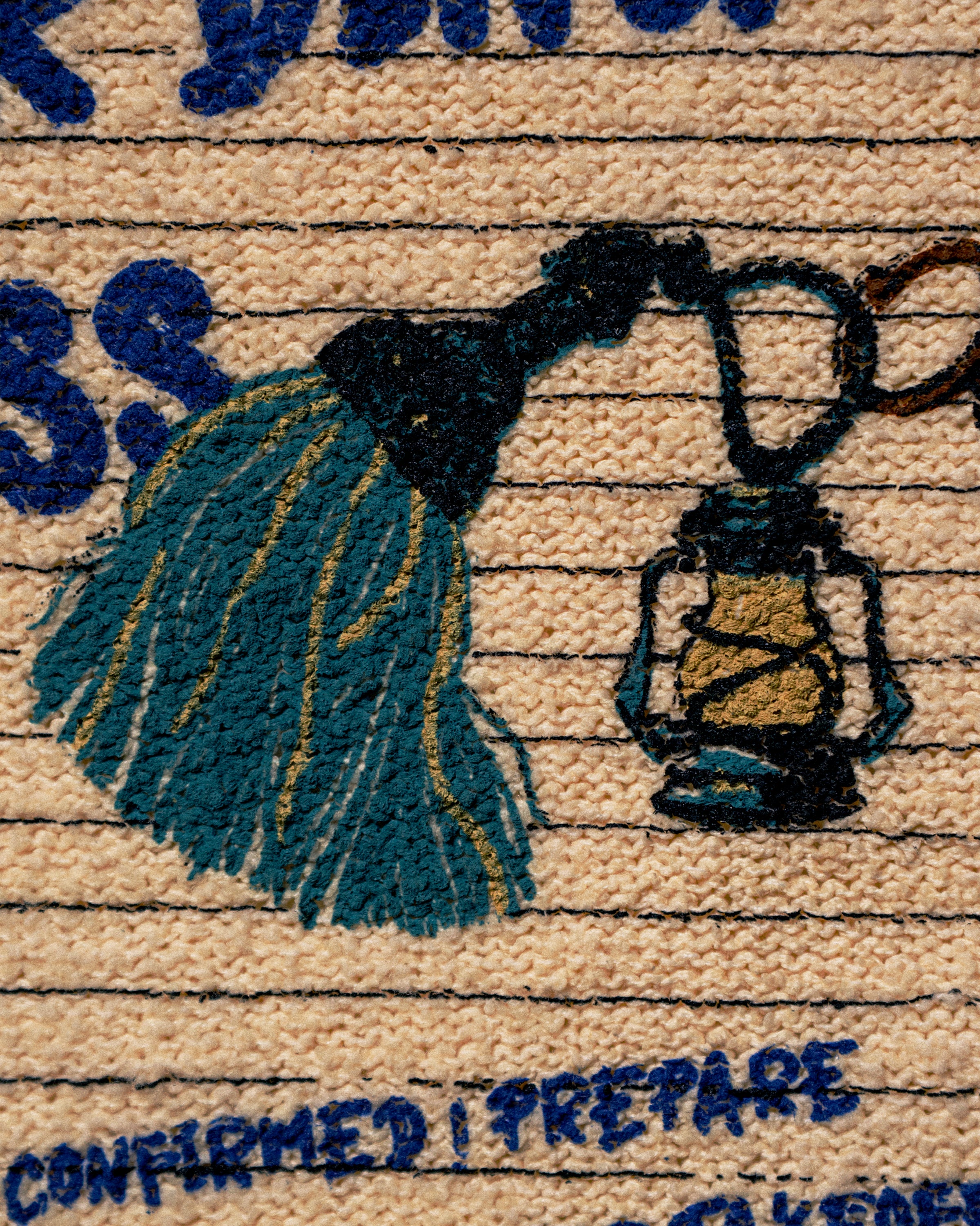 Close-up of a woven textile or rug showing a navy blue tassel and lantern motif on a beige background with horizontal stitched lines and partial blue text.